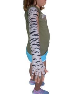 Mädchen mit Tiger-Kinderschminken lacht in die Kamera